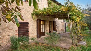 A stone building with a wooden door and a covered patio area.