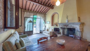 A rustic interior with a wooden dining table, a sofa, and a fireplace. - Amazing apartment in Casole d'Elsa with WiFi (Casole d'Elsa)