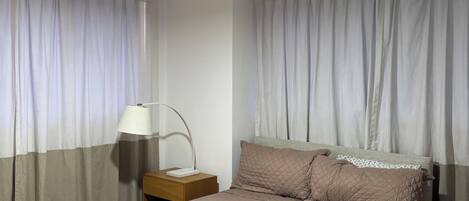 A bedroom with a bed, nightstands, a lamp, and a ceiling fan.