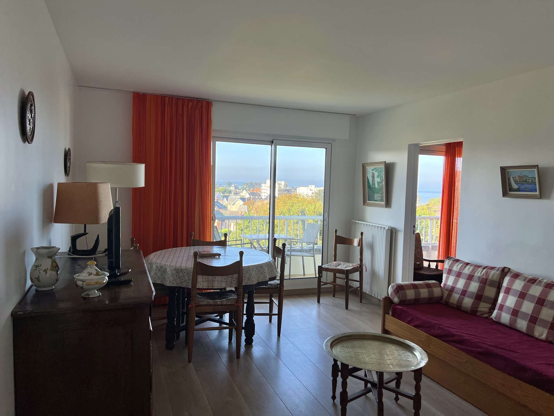 Ein Wohnzimmer mit Balkon, einem Esstisch und einer Couch.
