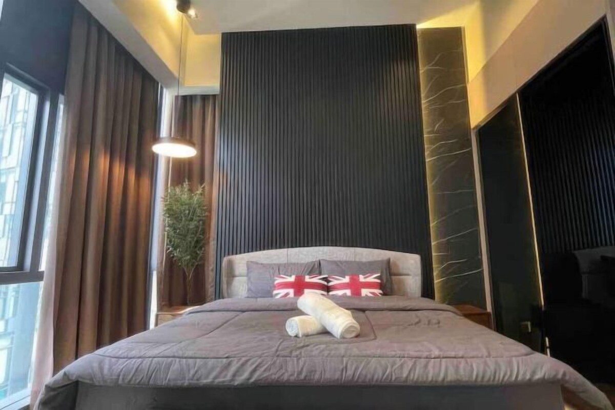 Een moderne hotelkamer met een groot bed, donker houten lambrisering en een groot raam.