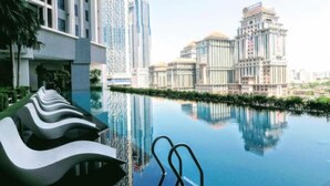A modern hotel with a swimming pool, high-rise buildings in the background, and a unique architectural design. - Twin Towers View The Mews (Kuala Lumpur)