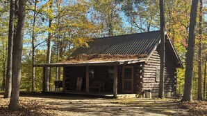 A rustic log cabin with a porch, surrounded by trees. - Immerse yourself in nature at High Ridge Cabin 3 (Mauckport)