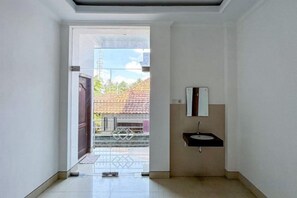 Un pasillo que conduce a un baño con un lavabo y un espejo.