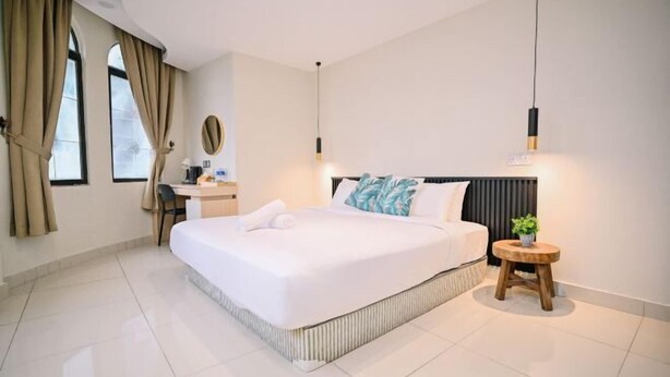 A modern hotel room with a large bed, a desk, and a small stool. - Swing & Pillows @ Central Market Kuala Lumpur (Kuala Lumpur)
