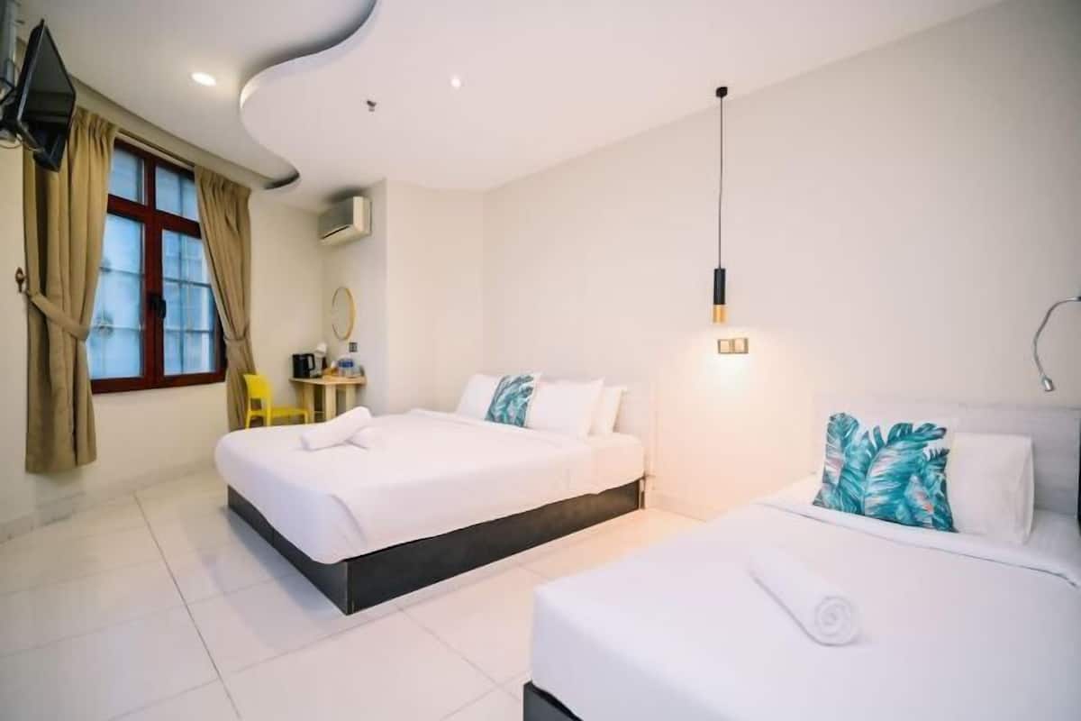 A modern hotel room with two beds, a desk, a chair, and a large window with curtains.