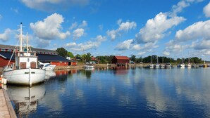 A marina with boats docked, a wooden pier, and buildings in the background. - 2 bedroom beautiful home in Påskallavik (Påskallavik)