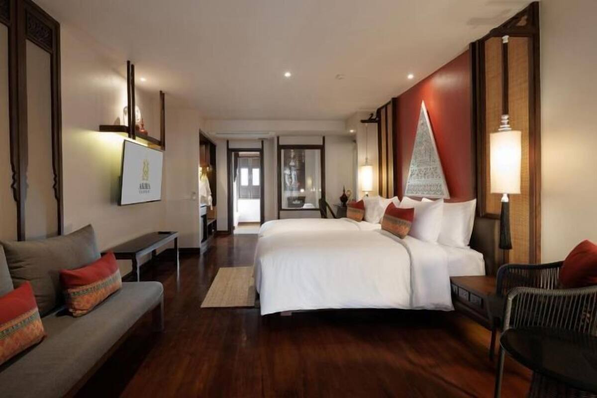 Habitación de hotel con una cama grande, un sofá, una silla y un escritorio.