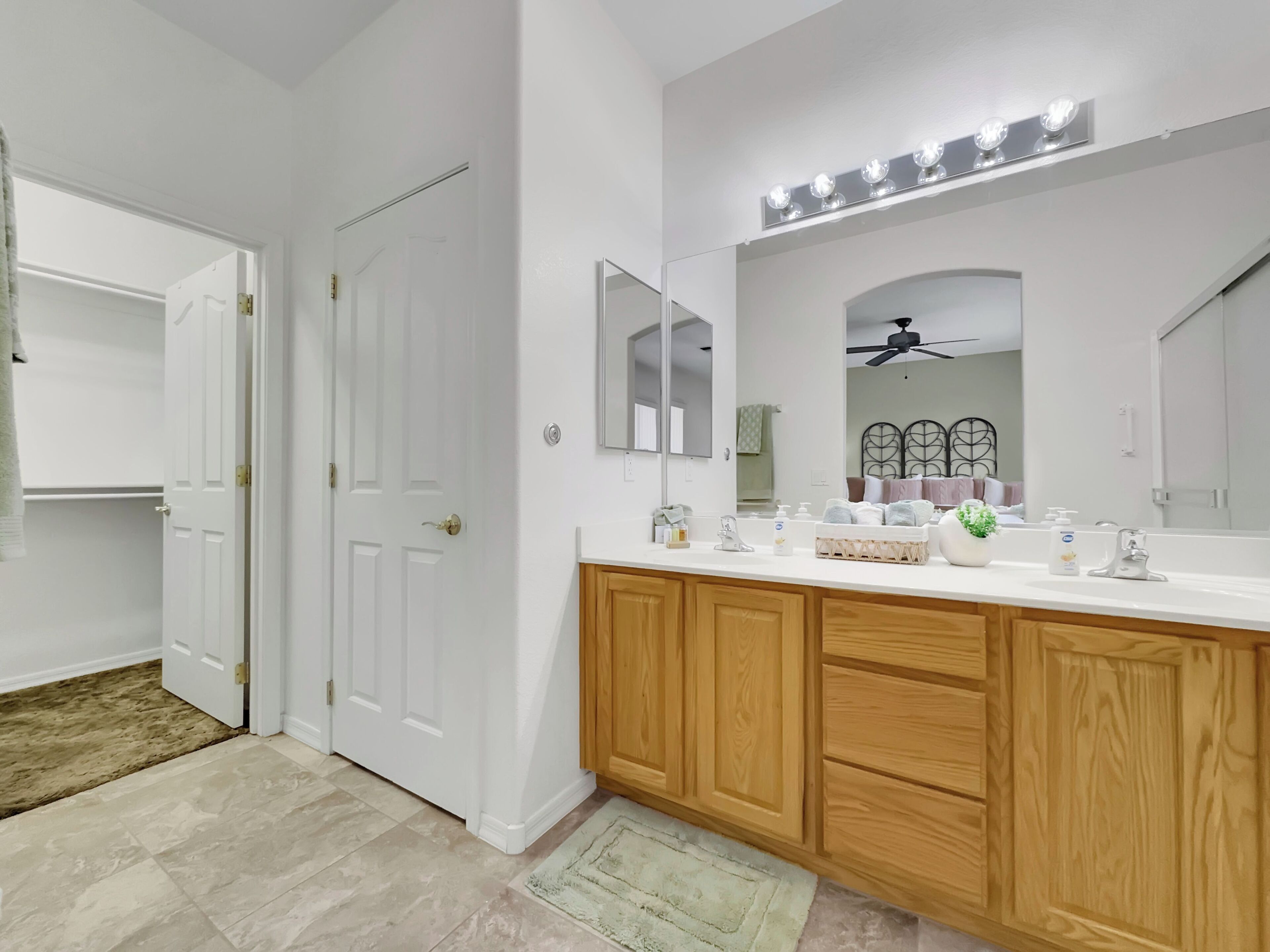 A modern bathroom with a vanity, mirror, and lighting.