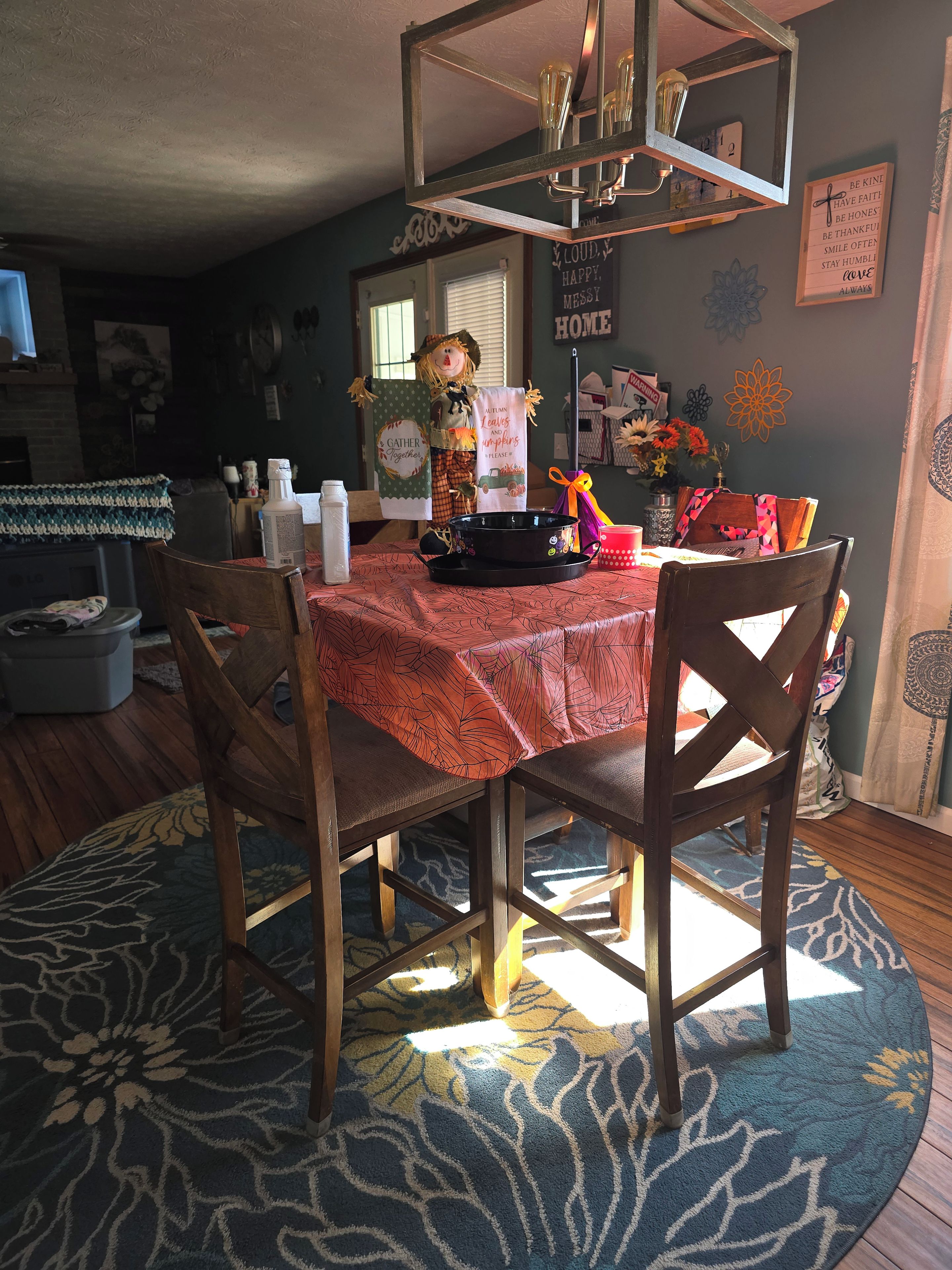 A dining area with a table set for two, a chandelier, and a wall with motivational quotes.