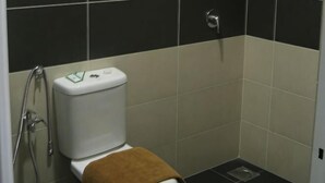 Un baño con inodoro, ducha y lavamanos.