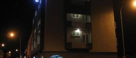 A multi-story building with illuminated windows and a visible entrance.