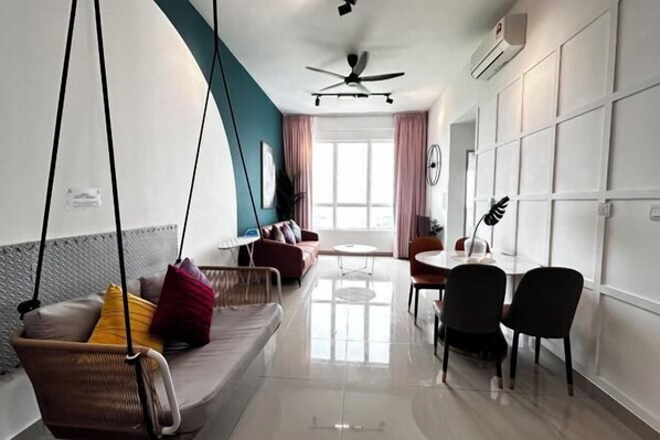 Un salon moderne comprenant un canapé, des fauteuils, une table à manger et un ventilateur de plafond.