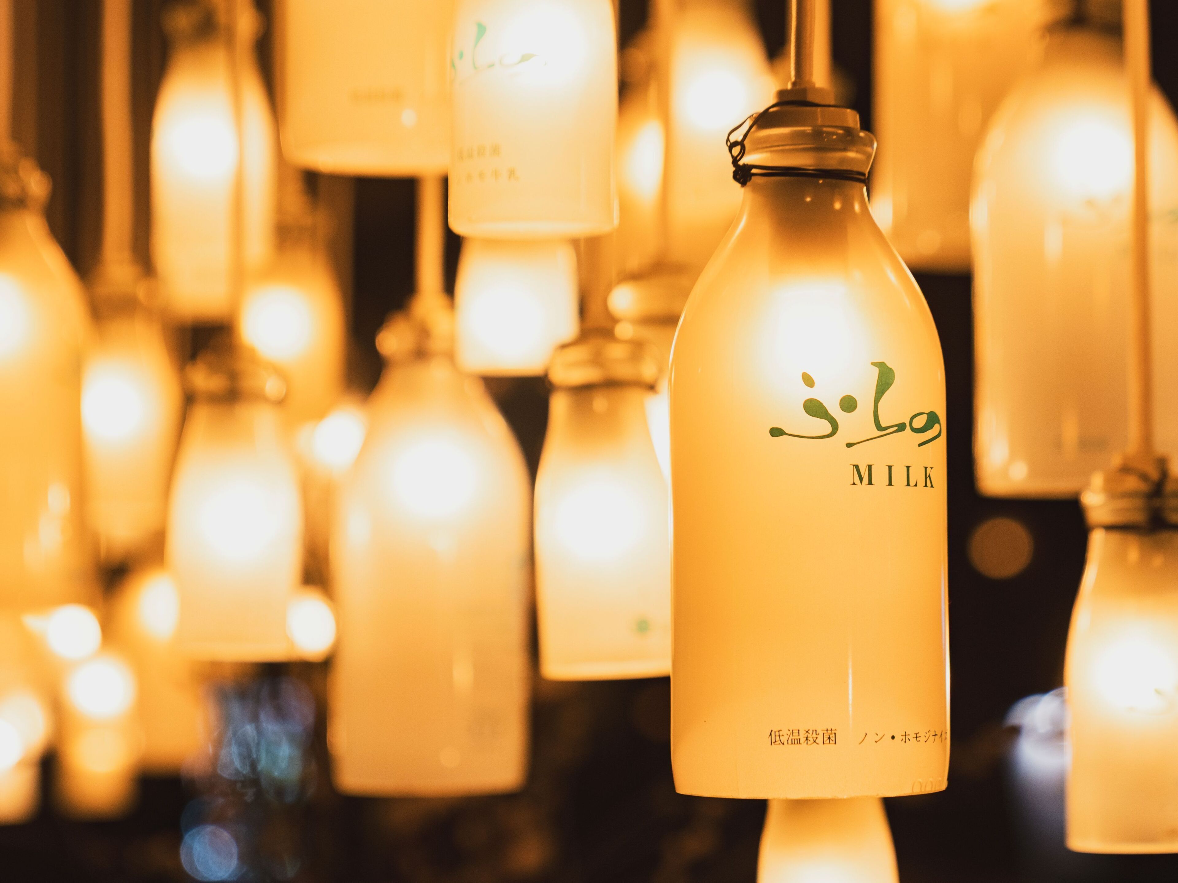 Una botella con etiqueta que incluye la palabra 'MILK' y texto en otro idioma.