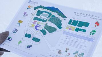 Mapa del jardín del Hotel Furano con zonas señalizadas, una pista de carrera y flores de temporada.