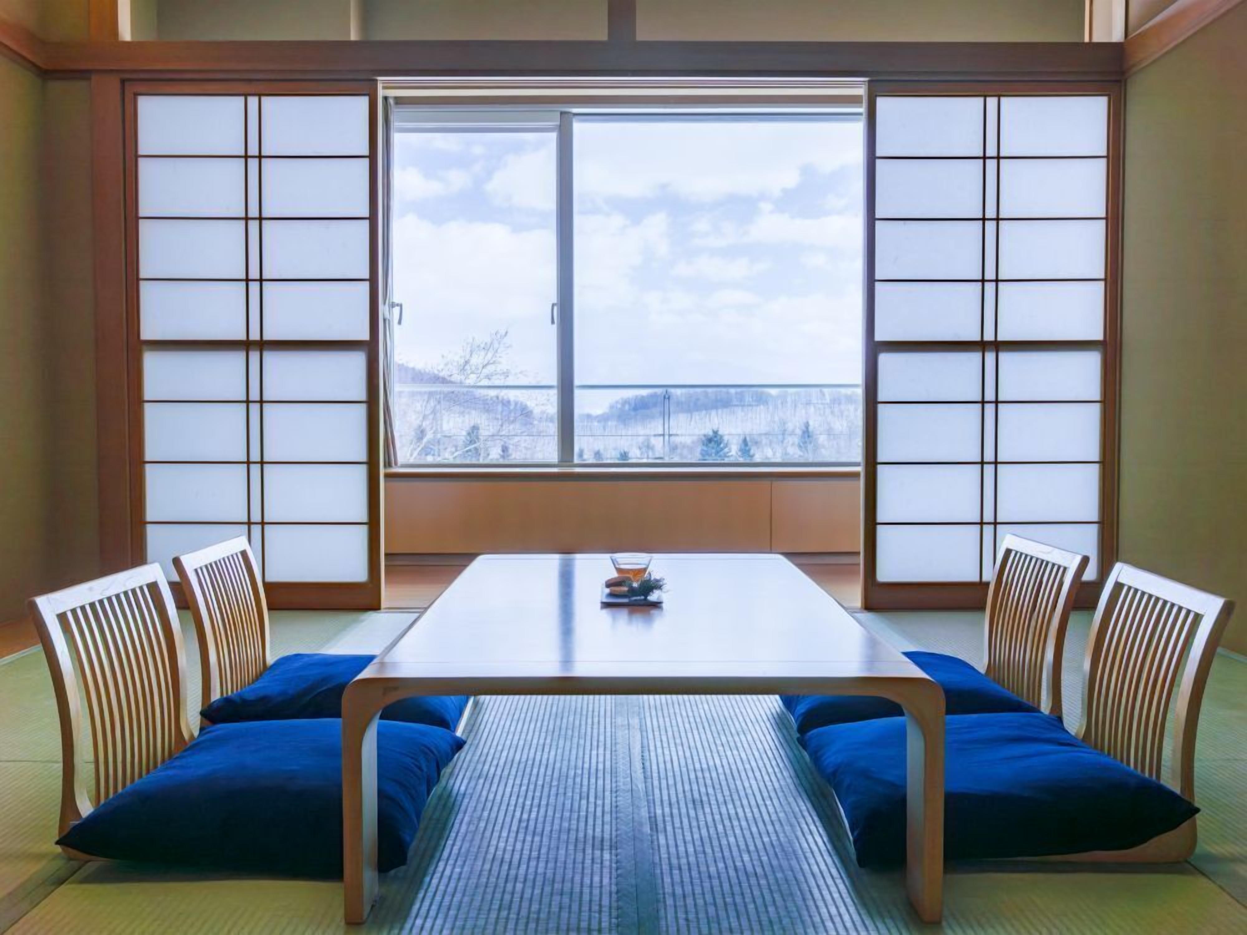 A traditional Japanese room with tatami flooring, a low table, and shoji screens.
