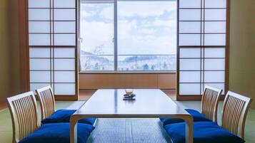 A traditional Japanese room with tatami flooring, a low table, and shoji screens.