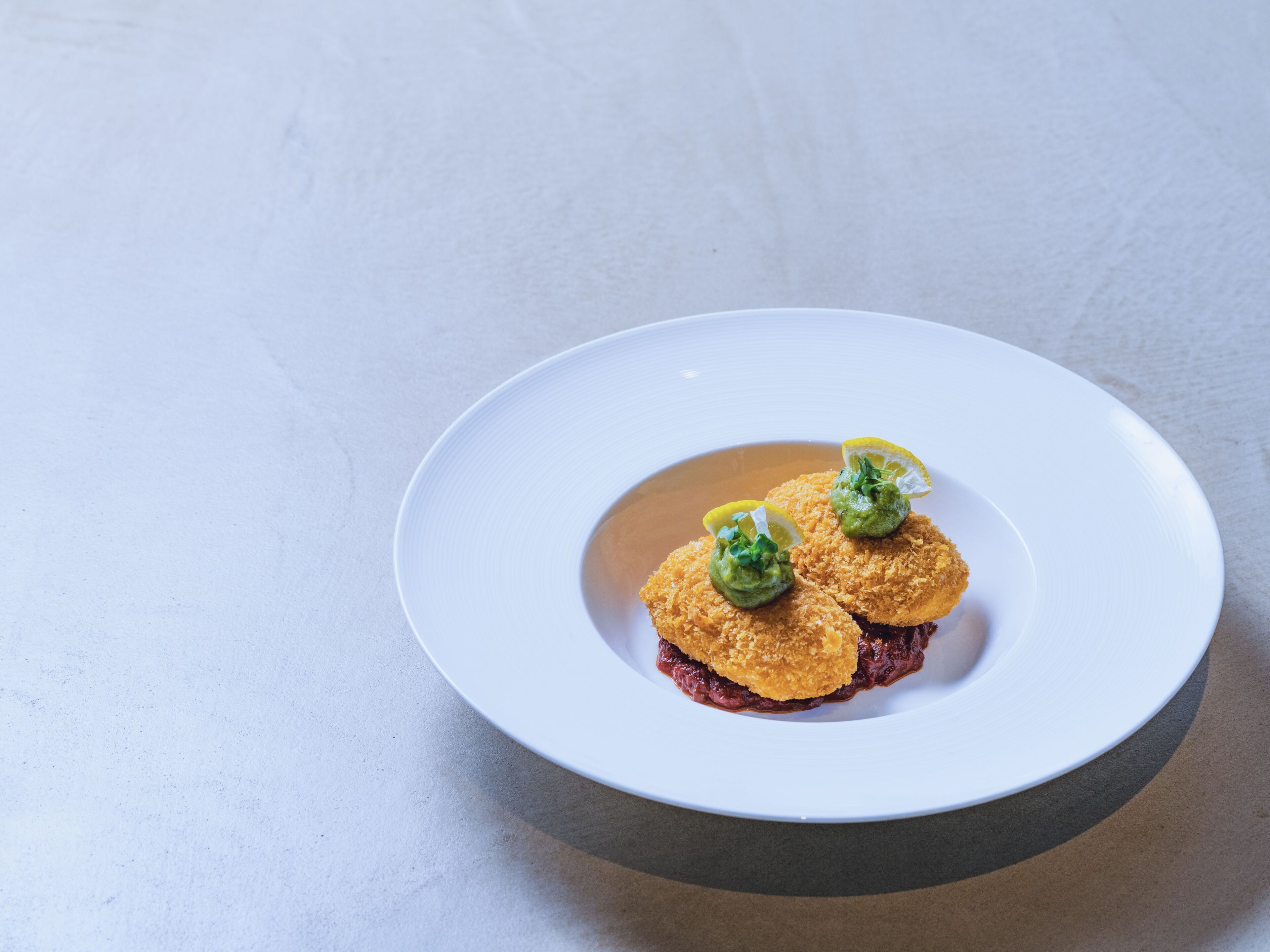 A white plate with two food items on a textured surface.