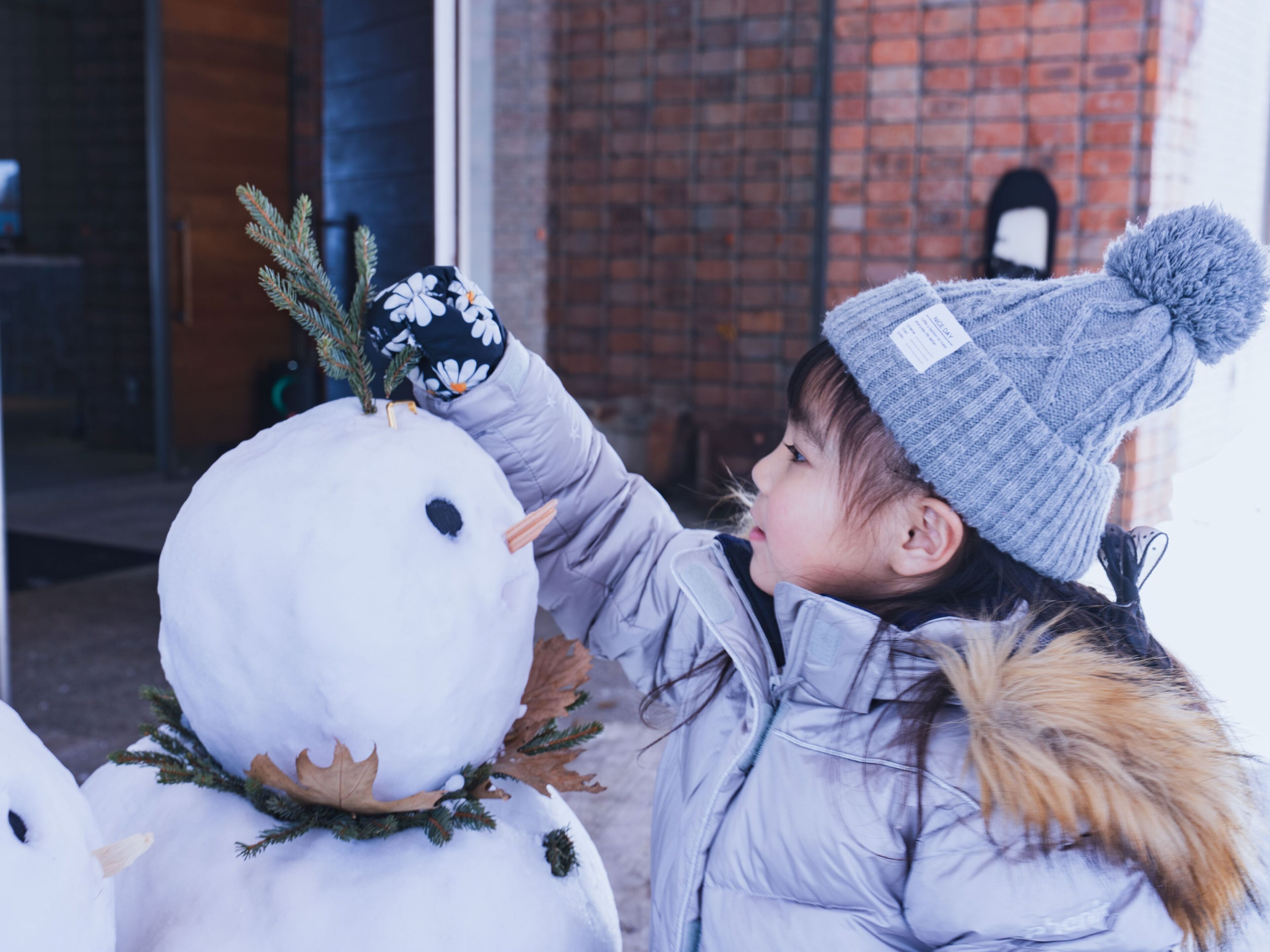 Un niño interactuando con un muñeco de nieve.