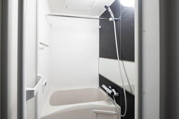A bathroom with a bathtub, a shower, and a towel rack. - Renaissance Court Jiyugaoka (Tokyo)