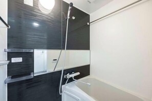 A modern bathroom with a bathtub, a shower, and a mirror. - Renaissance Court Jiyugaoka (Tokyo)