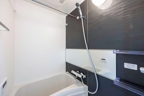A bathroom with a bathtub, a shower, and a mirror. - Renaissance Court Jiyugaoka (Tokyo)