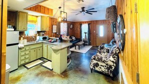 A spacious kitchen with wooden cabinets, a central island, and a ceiling fan. - The Apartment of GRACE! (Corpus Christi)