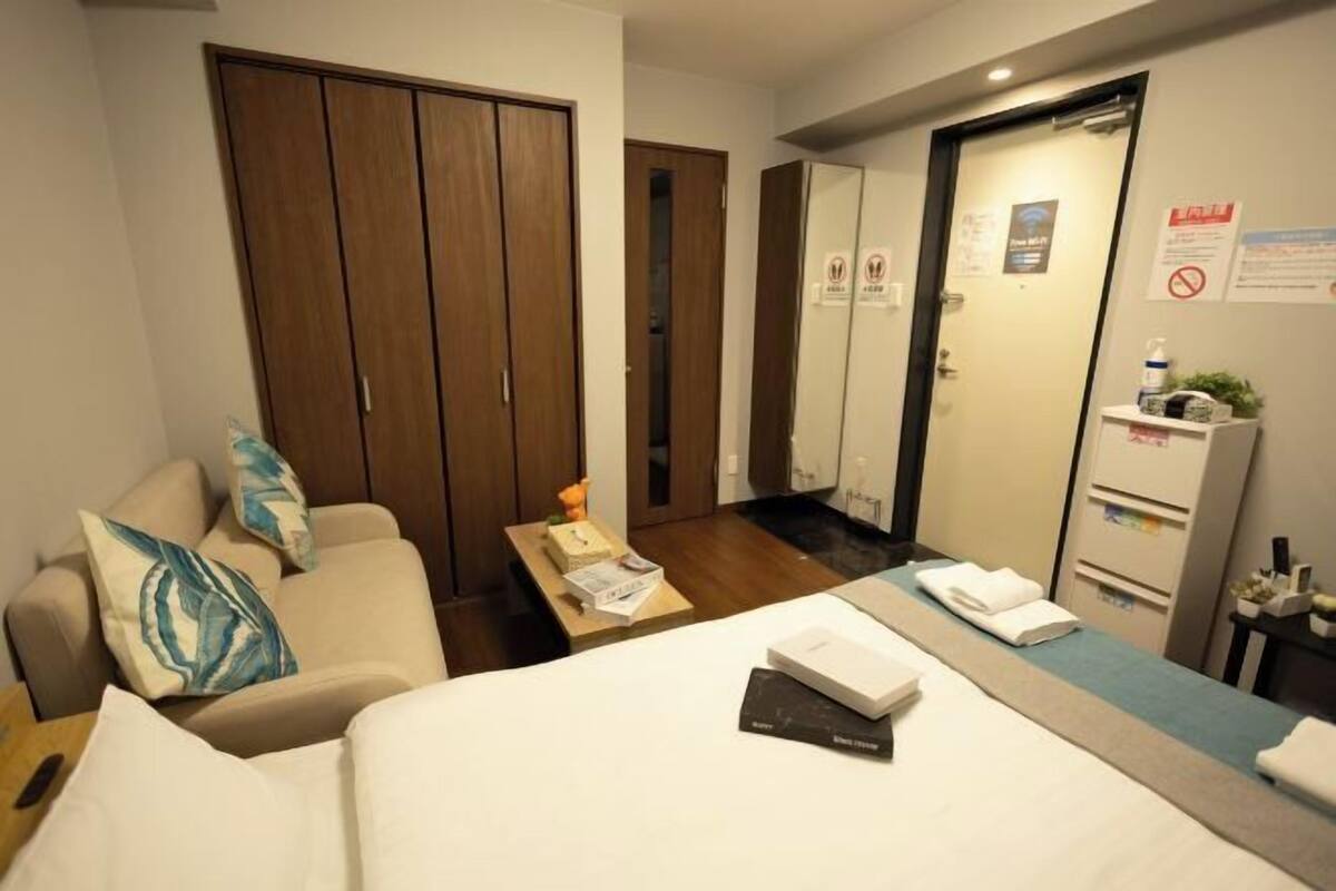 Een hotelkamer met een bed, een slaapbank, een bureau en een kledingkast.