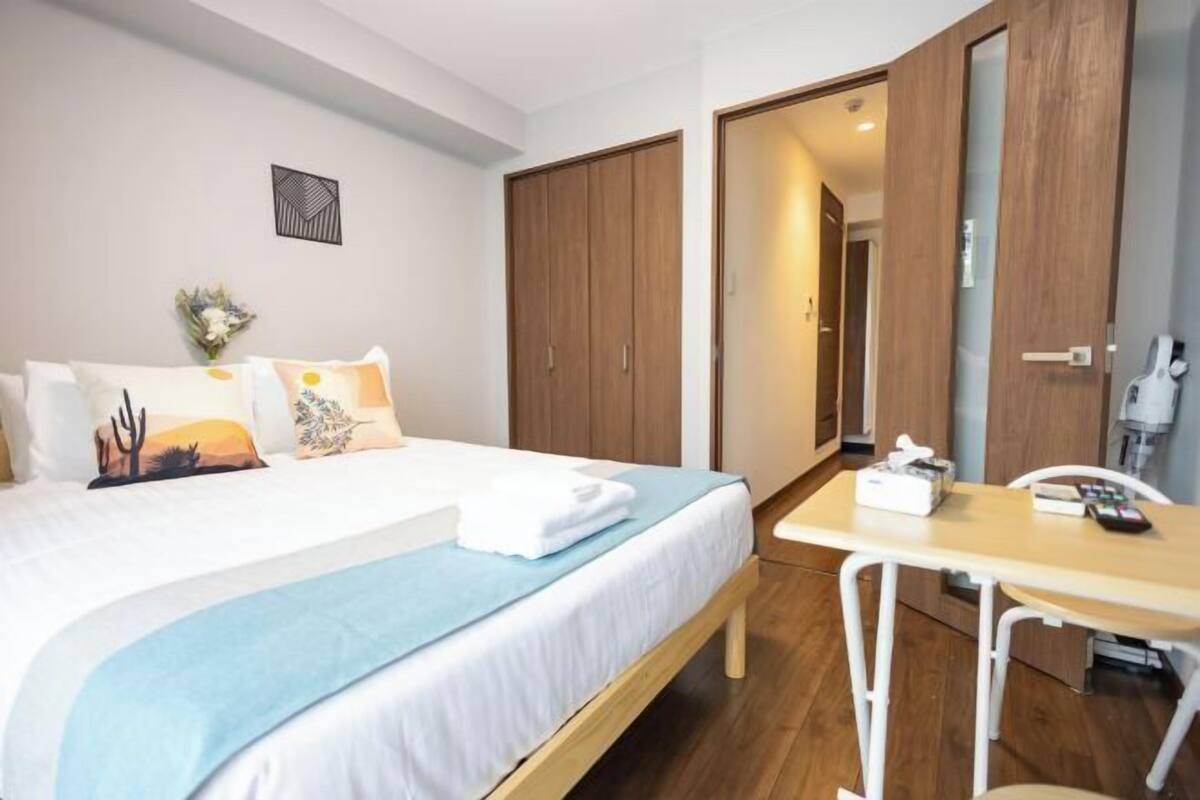 Een hotelkamer met een bed, een bureau en een kledingkast.