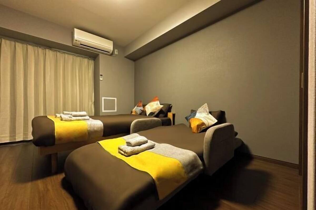 Een kamer met twee bedden, een massagetafel en een airconditioning.