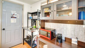 A compact kitchen with a microwave, sink, and storage cabinets. - 2 Mi to Lake Winnebago: Cozy Fond du Lac Studio (Fond du Lac)