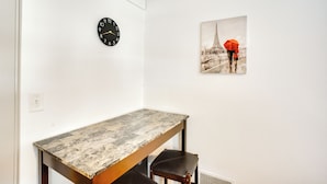 A room with a wooden table, a black clock, and a picture of the Eiffel Tower on the wall. - 2 Mi to Lake Winnebago: Cozy Fond du Lac Studio (Fond du Lac)