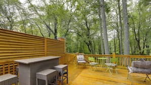 An outdoor deck with wicker furniture and a wooden railing.