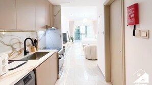 A modern kitchen with a marble backsplash, stainless steel appliances, and a view to a balcony. - Relaxing ST Getaway Balcony, Pool & Gym Access (Dubai)