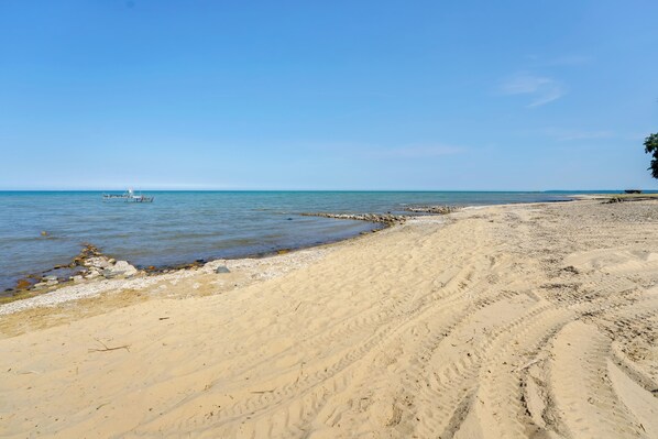 A sandy beach with a clear blue sky and calm sea. - Port Austin Studio: Fire Pit & Near Hiking Trails (Port Austin)