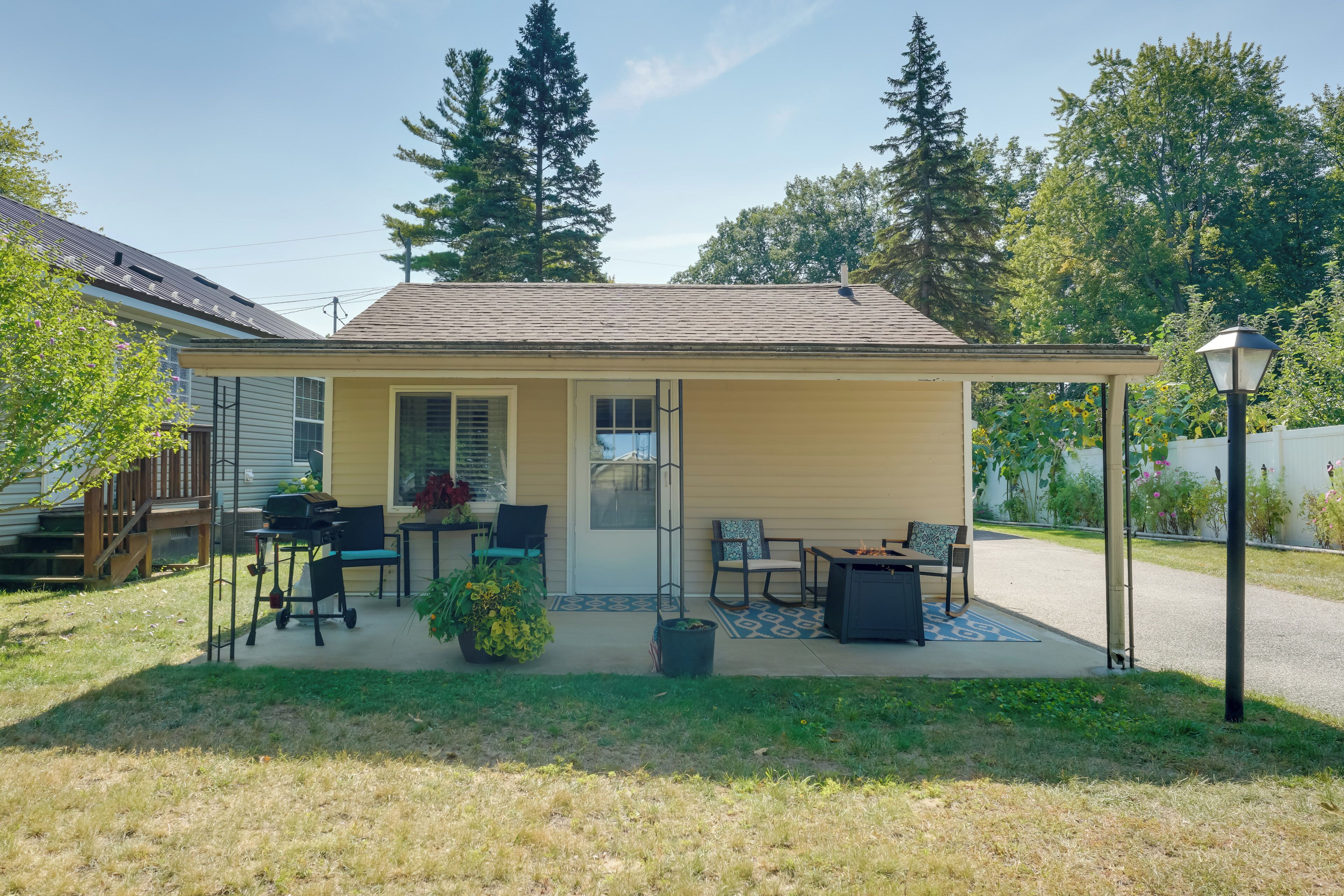 A single-story house with a covered patio, a small garden, and a fire pit.