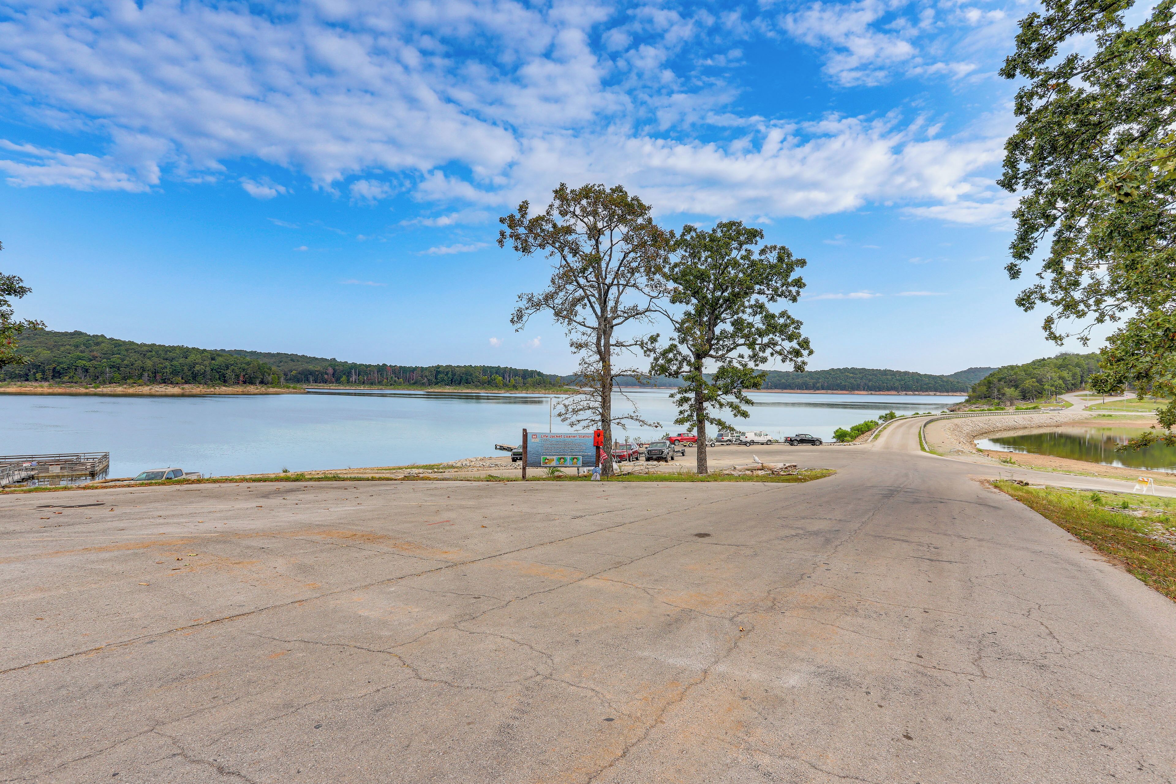 A paved road leading to a body of water with a Life Jacket Loaner Station sign.