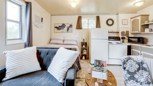 A compact living space with a sofa, a coffee table, a bed, a kitchen area, and a dining table. - Fish, Boat & Hike: Norfork Lake Studio Near Marina (Mountain Home)
