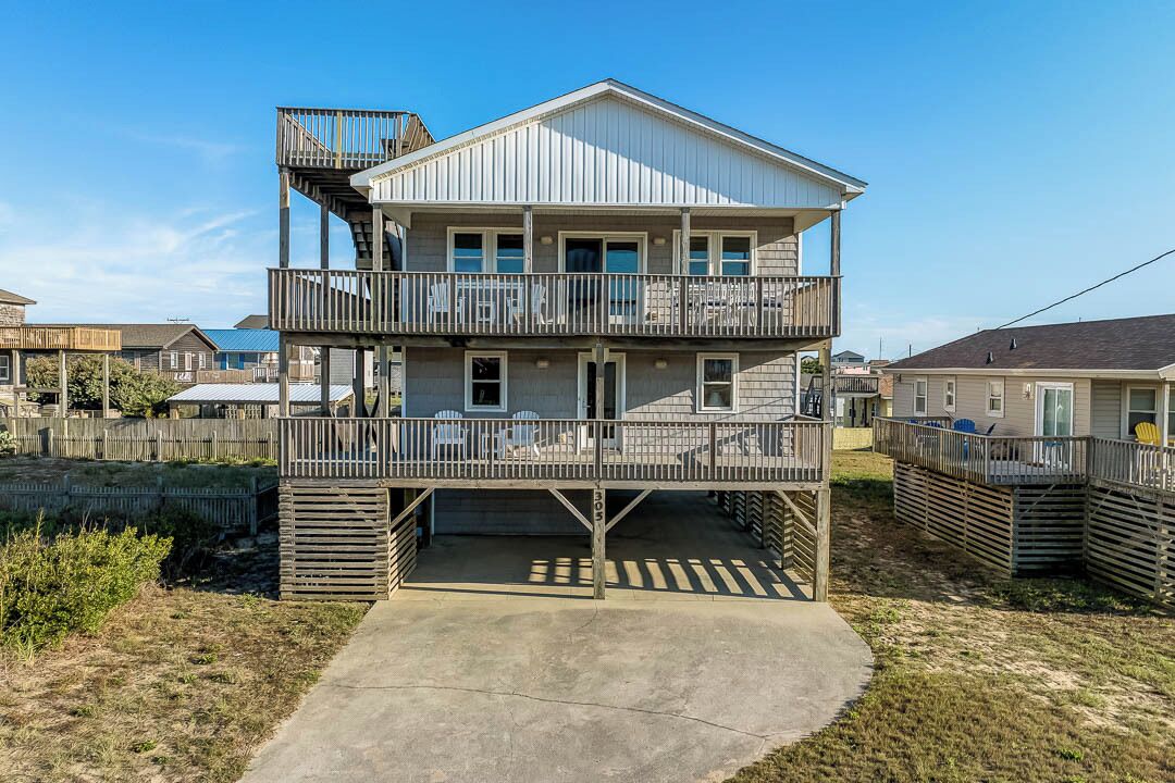 A two-story house with a balcony on the upper floor and a covered garage.