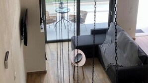 A modern interior with a staircase, a chandelier, and a view of the outdoors. - LefkoParga luxury Suites  (Parga)