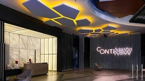 A modern hotel lobby with a reception desk, a seating area, and a distinctive ceiling design. - Continew Residence by Janice's Homestay (Kuala Lumpur)