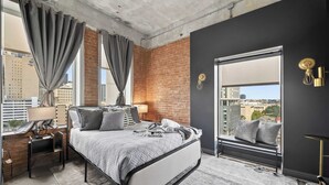 Un dormitorio moderno con una cama grande, un escritorio y una ventana con cortinas.