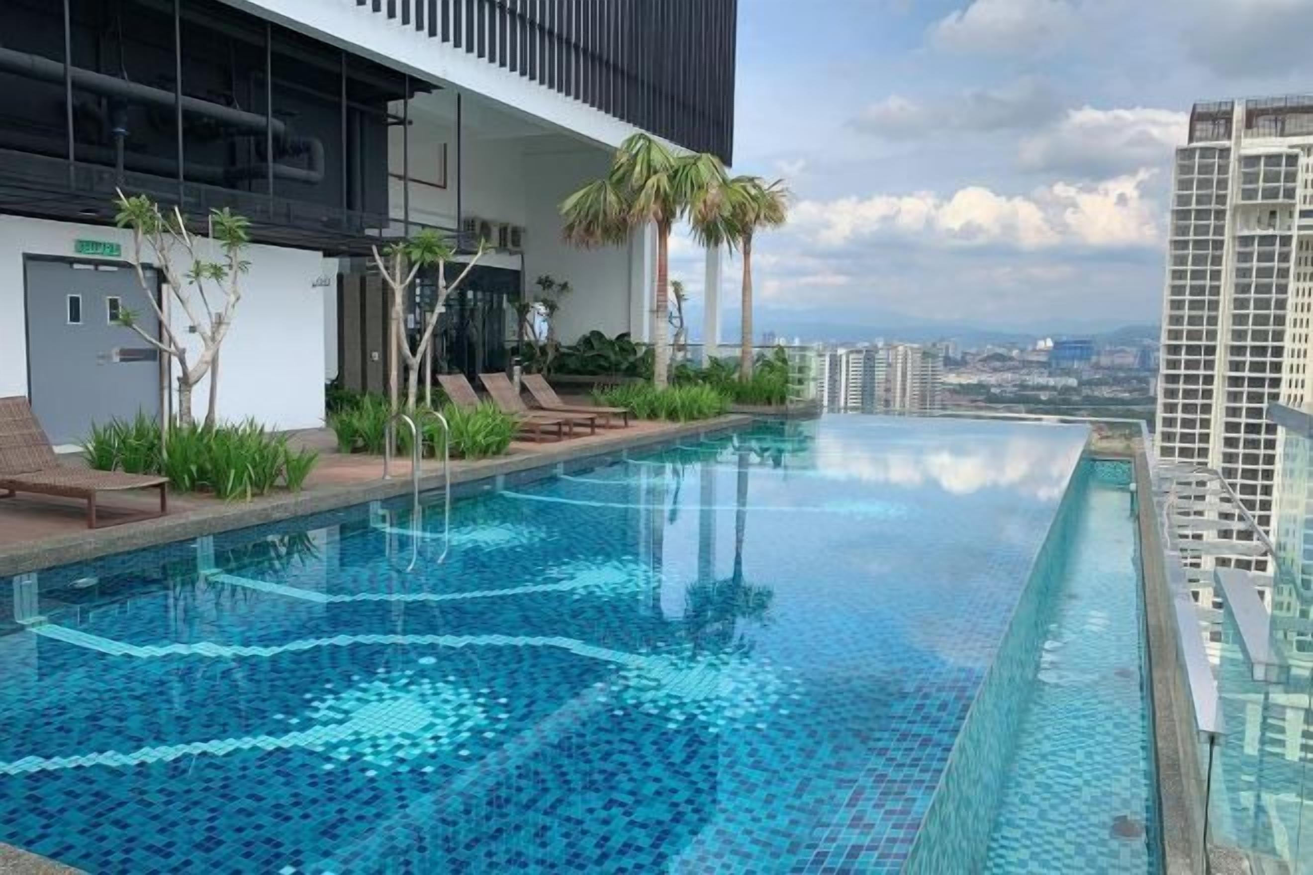 Ein Dachpool mit Infinity-Kante und freiem Blick auf die Stadtlandschaft, umgeben von modernen Gebäuden und Palmen.