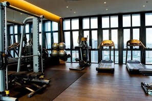 A gym with exercise equipment, large windows, and a city view. - Homestay In Aurora Place, Bukit Jalil (Kuala Lumpur)