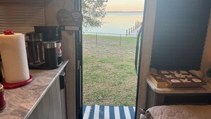 Una kitchenette con cafetera, dispensador de toallas de papel y un cartel dando la bienvenida a los huéspedes.