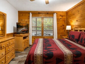 Ein Zimmer mit einem Bett, einem Schreibtisch, einem Fernseher und einem Fenster mit Jalousien.
