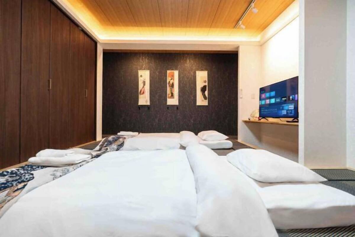 A modern hotel room with a large bed, a flat-screen TV, and artwork on the wall.
