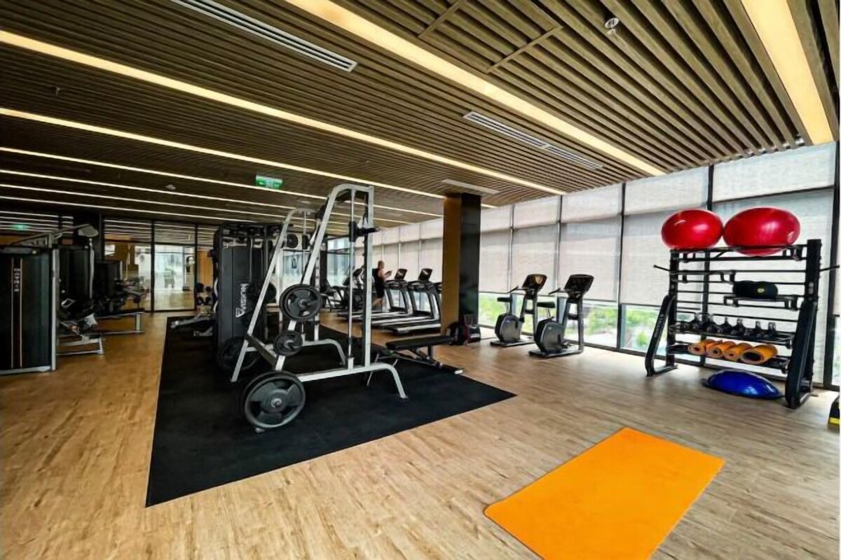 A gym with cardio equipment, weight machines, and a rack of dumbbells.