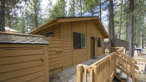 A wooden cabin with a porch and a small deck. - Timber 12 - Cabin, SHARC Passes + Walkable, Private Hot Tub (Sunriver)