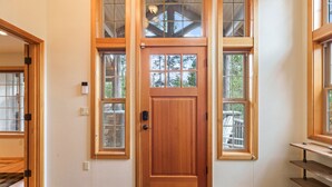 A wooden front door with a glass panel, flanked by two windows with wooden frames. - Tokatee 14 - Beautiful & Spacious, SHARC, Ping Pong, A/C, Hot Tub (Sunriver)
